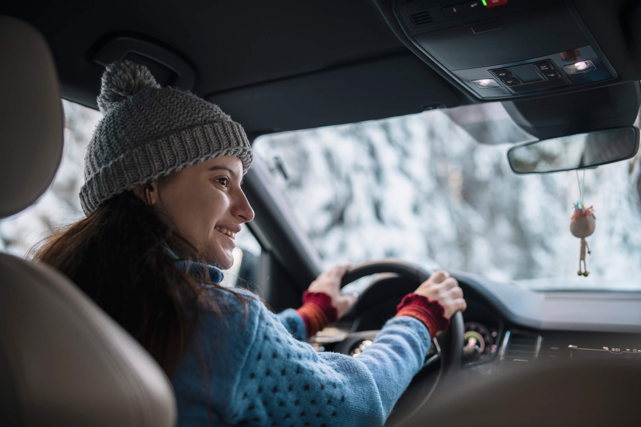 Woman in winter gear driving on a snowy winter trail