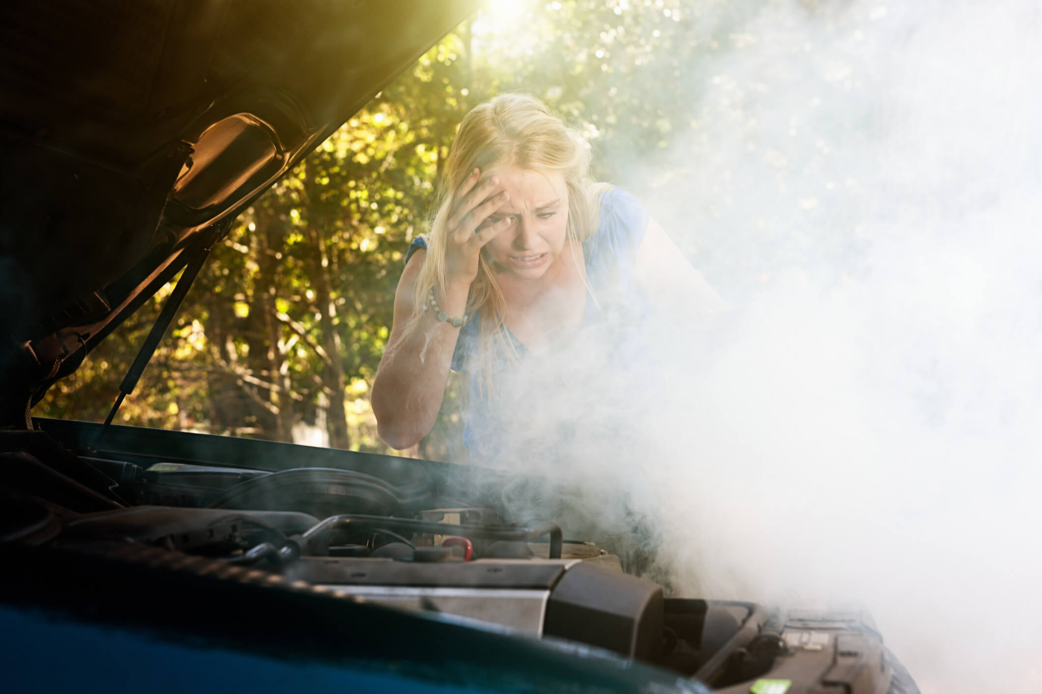 woman shocked by smoke or steam pouring from her car engine